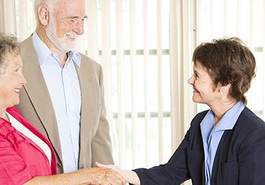 Senior couple meets with a friendly financial adviser.